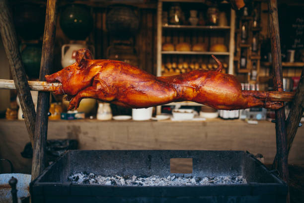 schwein ist am spieß braten - pig roasted spit roasted domestic pig stock-fotos und bilder