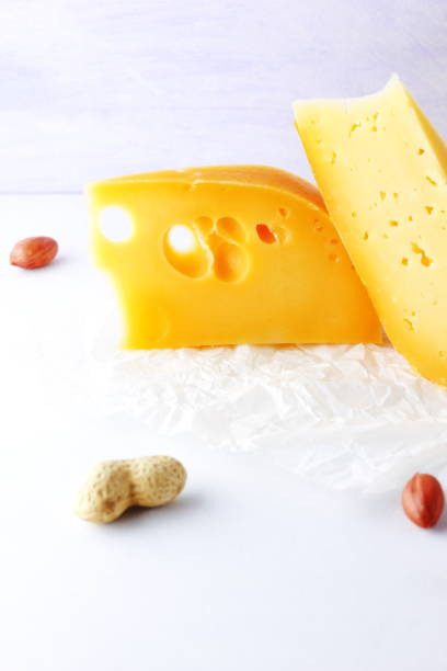 istock Various cheeses, pears and peanuts on white background. Blue cheese and camembert on parchment paper. Dairy products and fruits for breakfast. Healthy food. Copy space 1083067936