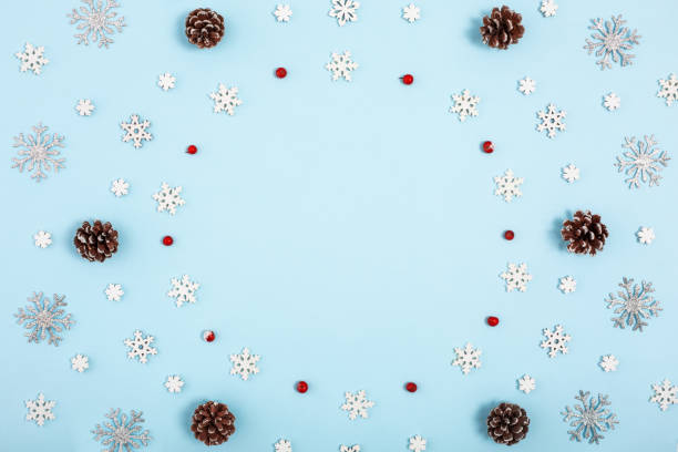 istock Christmas ring frame on pastel blue background. Snowflakes, cones, berries. View from the top. 1083070422