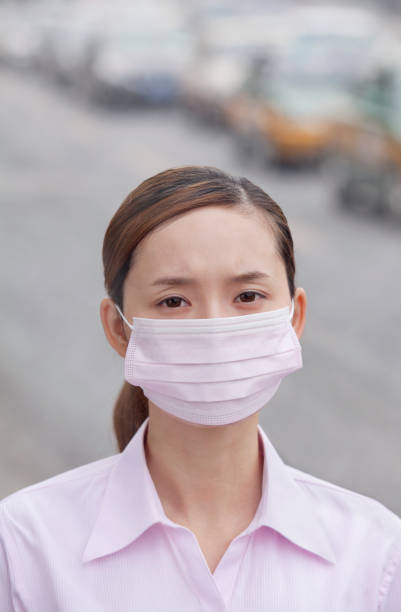 도시에 있는 대기 오염 때문에 얼굴 마스크를 착용 하는 중국 여자 - beijing air pollution china smog 뉴스 사진 이미지