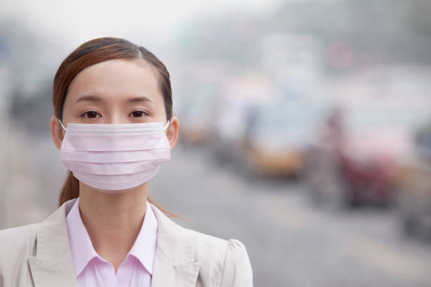 도시에 있는 대기 오염 때문에 얼굴 마스크를 착용 하는 중국 여자 - beijing air pollution china smog 뉴스 사진 이미지