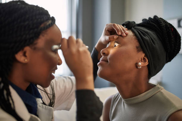 istock Female doctor checking young patient's eye 1083080570