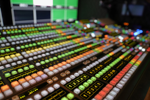 Broadcast Video Switcher used for live events and television production, with colorful lights and buttons
