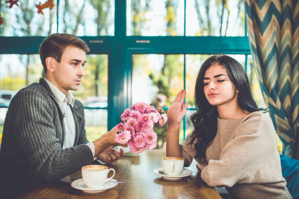 The woman reject a flowers from her man in the restaurant stock photo