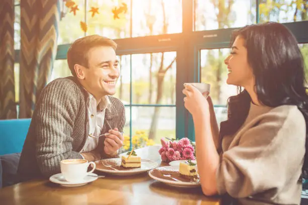 Photo of The happy man and woman eating a cake in the cafe