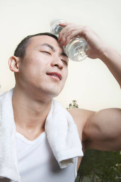 istock Chinese man holding cool water to forehead after exercise 1083083930