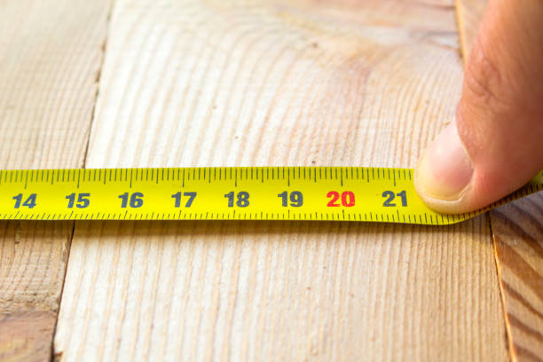 istock Measure with a tape measure on a wooden board 1083085586