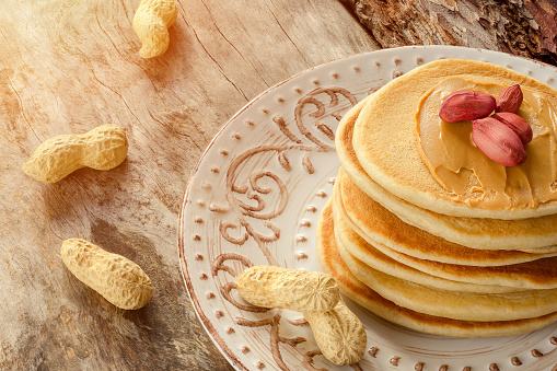 Stack Of Hot Pancakes On The Plate. Pancakes With Peanuts And Peanut Butter For A Breakfast. Close-up