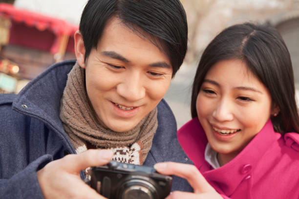 istock Chinese couple looking at digital camera 1083087934