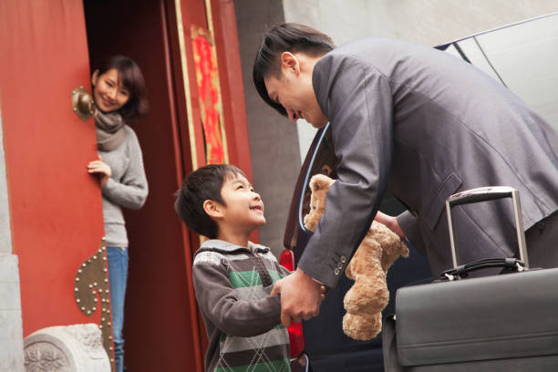 istock Chinese mother and son greeting returning father 1083089300