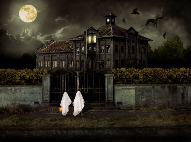 dzieci w kostiumy ducha cukierek albo psikus na swoje podwoje otwierają nawiedzone house - haunted house zdjęcia i obrazy z banku zdjęć