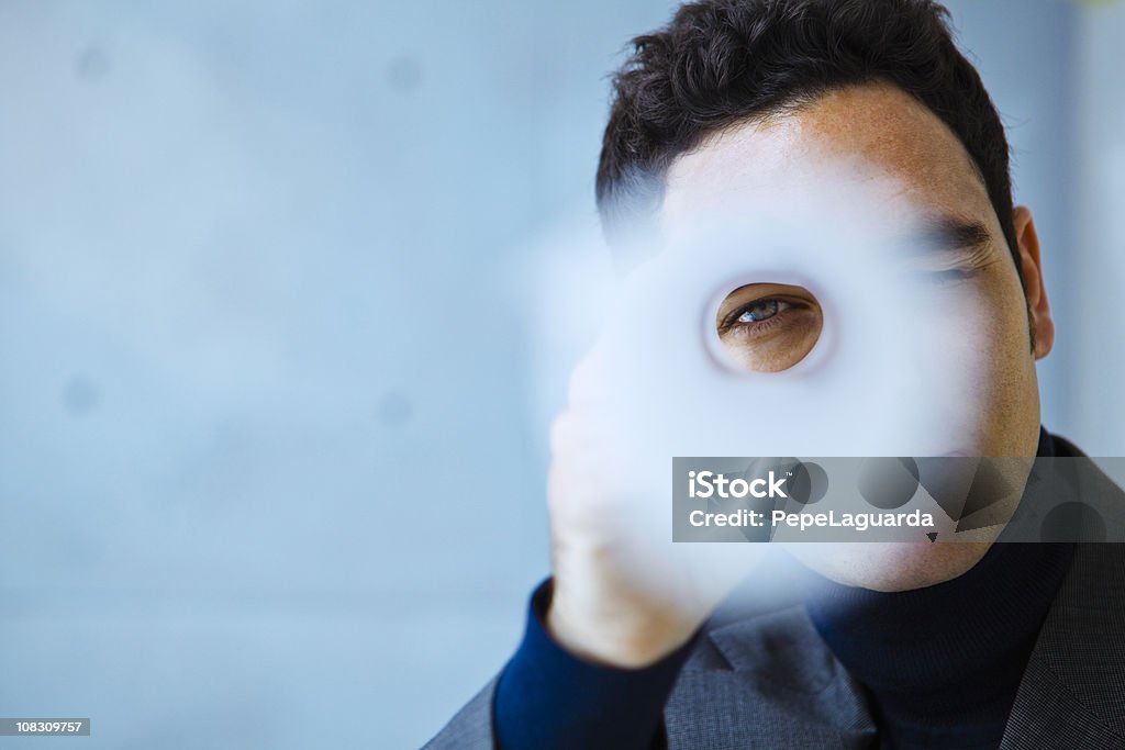 Arquitecto mirando a través de un rollo de blueprints - Foto de stock de Círculo libre de derechos