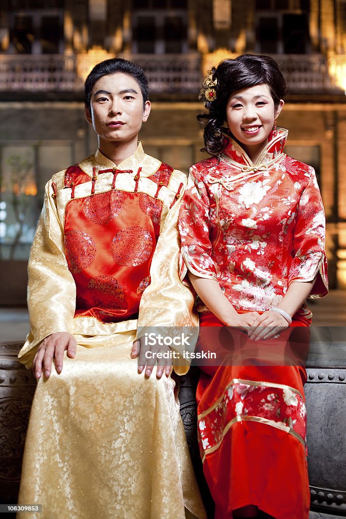 Asian traditional couple Asian traditional couple, sitting together ant night in traditional clothes. Just married. Hands on knees. Woman smiling. Couple - Relationship Stock Photo