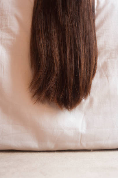 Chinese woman's hair hanging off bed
