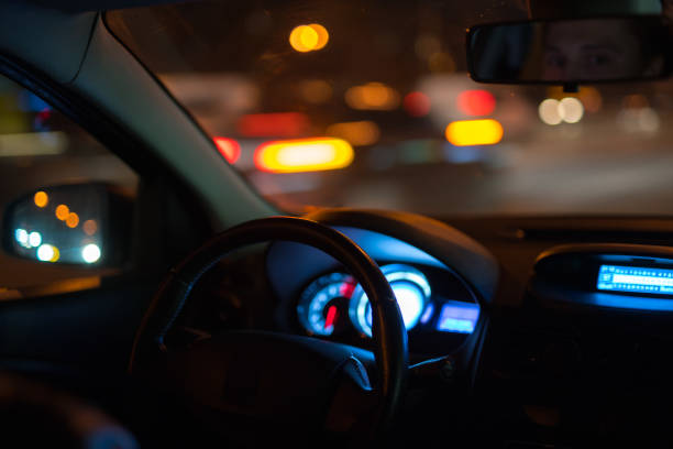 istock The man look to the mirror inside the car. Evening night time 1083100912