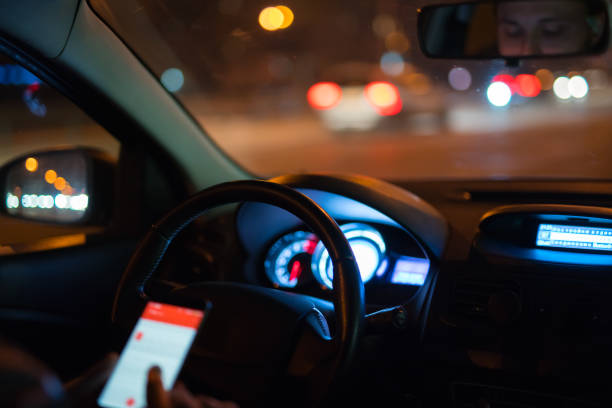 istock The man phone in the car. Evening night time 1083100924