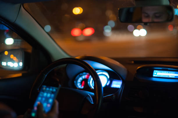istock The man phone in the car. Evening night time 1083100926
