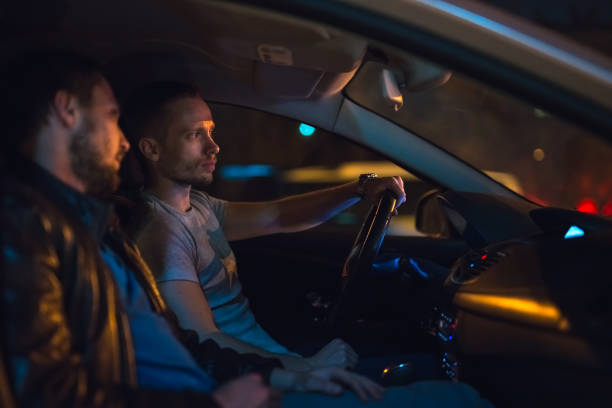 istock The men sit inside the car on the road. Evening night time 1083100964