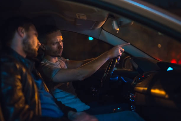 istock The men sit and gesture inside the car on the road. Evening night time 1083100968