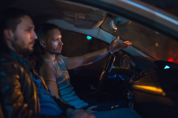 istock The men sit and gesture inside the car on the road. Evening night time 1083100972