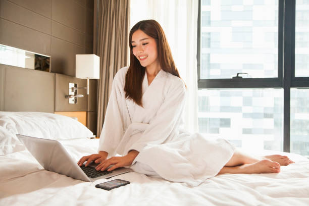 istock Chinese woman using laptop on bed 1083103964