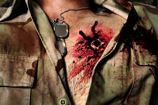 High Caliber Bullet Wound *THIS IS NOT REAL - SPECIAL EFFECTS MAKE UP*  Military man in desert camouflage  with high caliber gun shot wound to his left chest.  This picture works for medical, military, or halloween.  face paint halloween adult men stock pictures, royalty-free photos & images