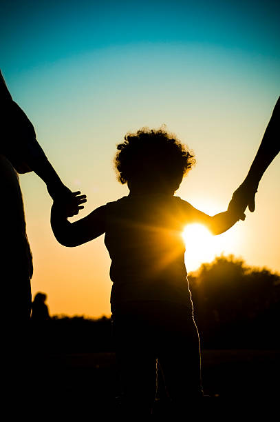 silueta de child holding hands - holding hands child silhouette family fotografías e imágenes de stock