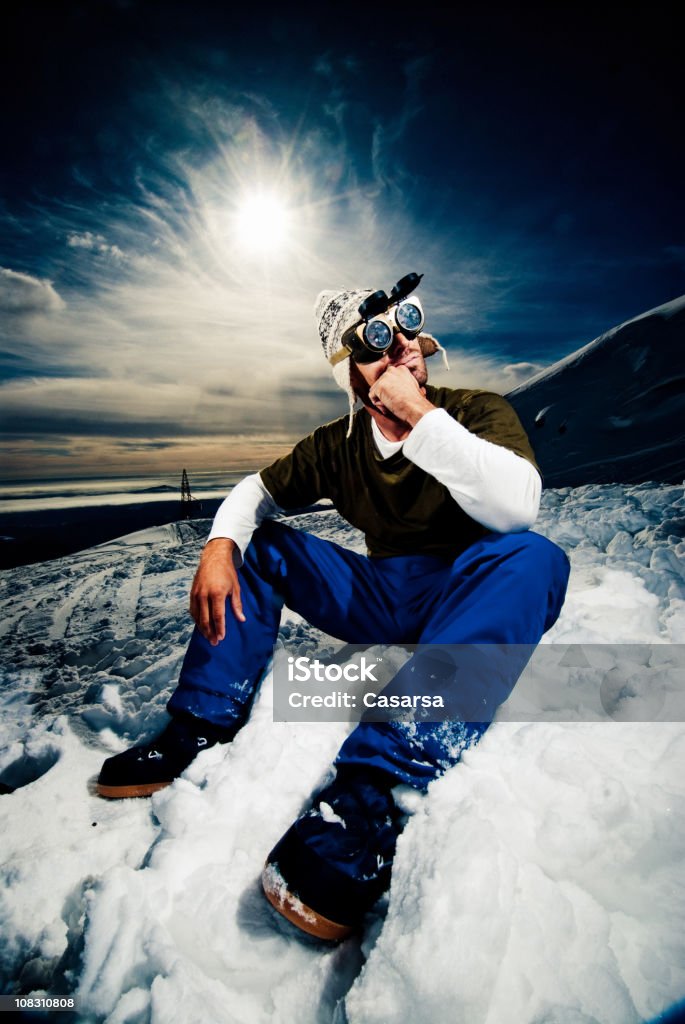 Joven sentado en la nieve - Foto de stock de 25-29 años libre de derechos