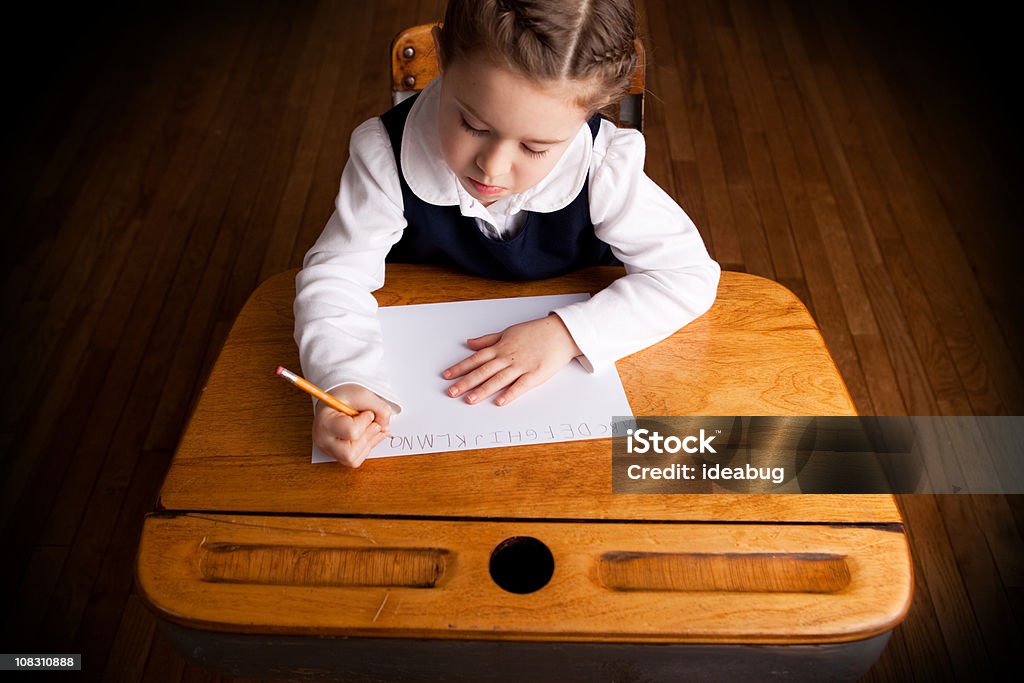 Junges Mädchen Schüler schreiben in Schule Schreibtisch und Sitzbereich - Lizenzfrei 6-7 Jahre Stock-Foto