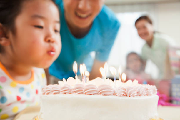 ragazza cinese che spegne candele sulla torta di compleanno - birthday family party cake foto e immagini stock