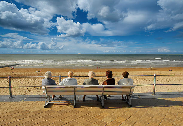 Five Old ladies sitting on bench chilling out near sea stock photo