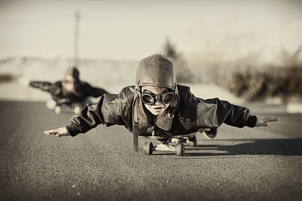 Skateboard Aviators A couple of young boys love to fly, albeit down a hill on a skateboard. piloting photos stock pictures, royalty-free photos & images