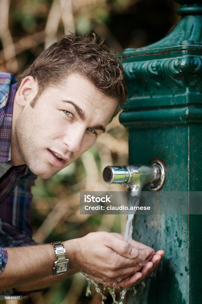 Junge Mann trinkt aus einem Springbrunnen. Farbe - Lizenzfrei 25-29 Jahre Stock-Foto