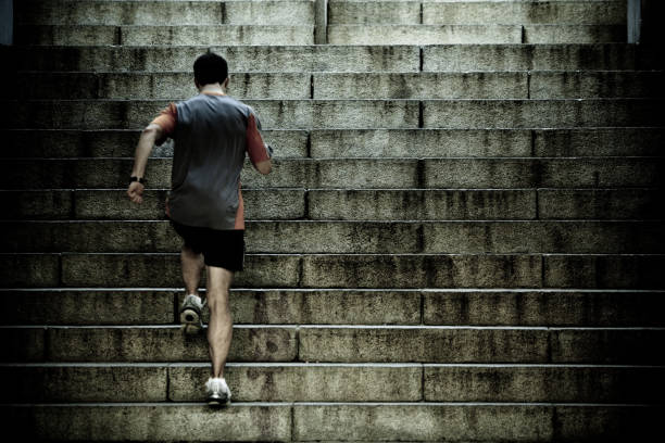 Runner training on stair intervals Athlete training on steep old worn concrete stairs - toned image for dramatic feel.  steep photos stock pictures, royalty-free photos & images