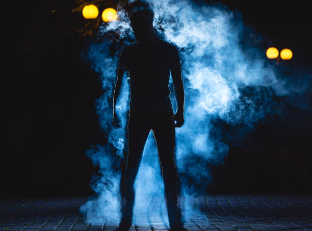 istock The man stand on the blue smoke background. night time 1083113460