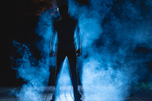 sylwetka mężczyzny na ulicy na tle dymu. połów nocny - street fog profile zdjęcia i obrazy z banku zdjęć