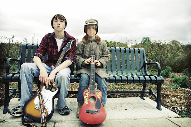 ボーイズがギターのベンチに座る - parker brothers 写真 ストックフォトと画像