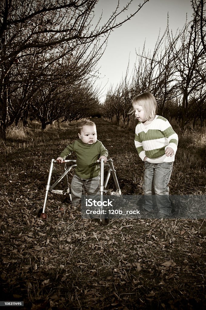 brother and sister playing in an orchard  Child Stock Photo