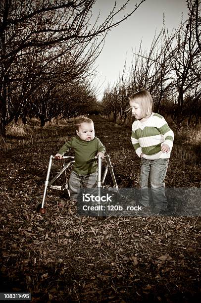 Brother And Sister Playing In An Orchard Stock Photo - Download Image Now - Child, Dependency, Individuality