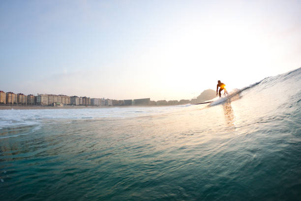surfer on wave at sunset