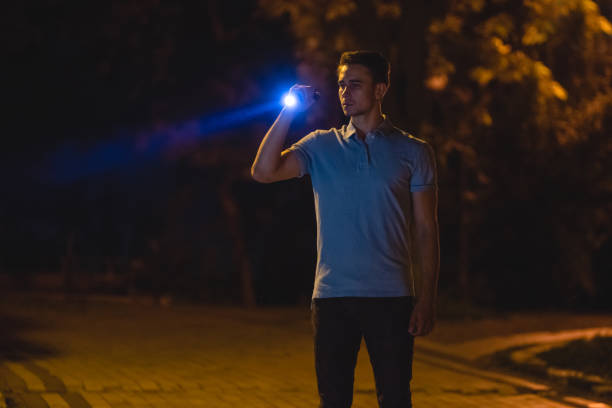 l'uomo bello stare con una torcia elettrica sulla strada buia. notte - equal opportunity flash foto e immagini stock