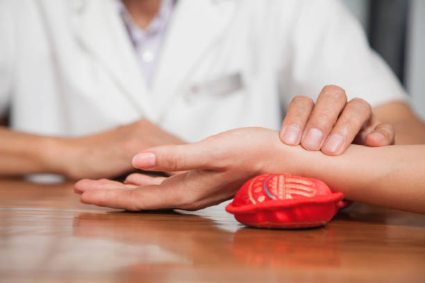 close up of man checking woman's pulse - chinese traditional medicine imagens e fotografias de stock