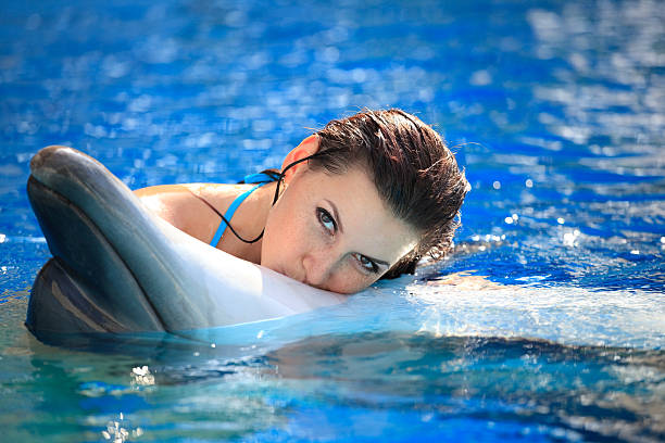 istock young woman kissing a dolphin 108311818