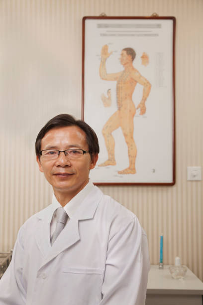 chiński lekarz uśmiechając się w biurze - chinese medicine alternative medicine chinese culture herbal medicine zdjęcia i obrazy z banku zdjęć