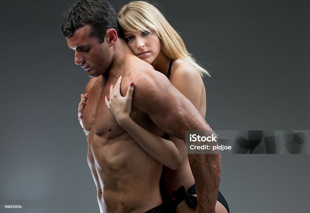 young woman holding nude muscular man XXXL  Young Couple Stock Photo