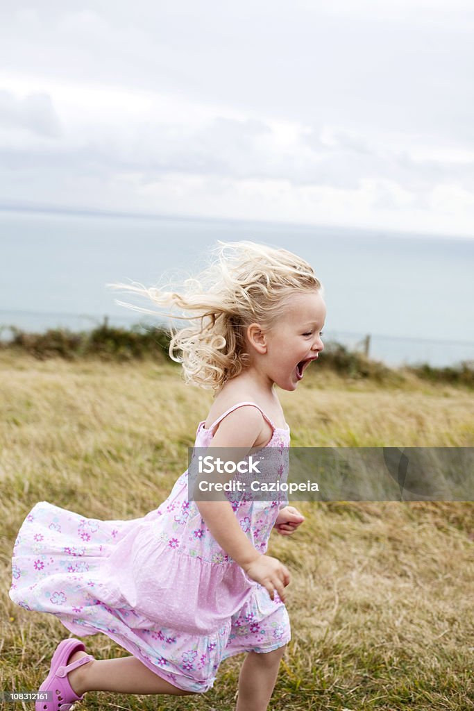 Niña corriendo en el campo - Foto de stock de Condado de Kent - Inglaterra libre de derechos