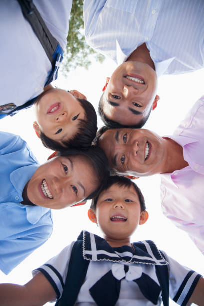istock Chinese family smiling together outdoors in school uniform 1083123402