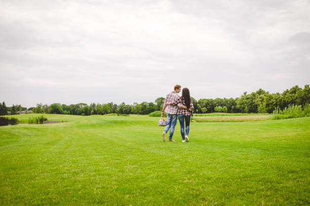 The man and woman walking on the grass