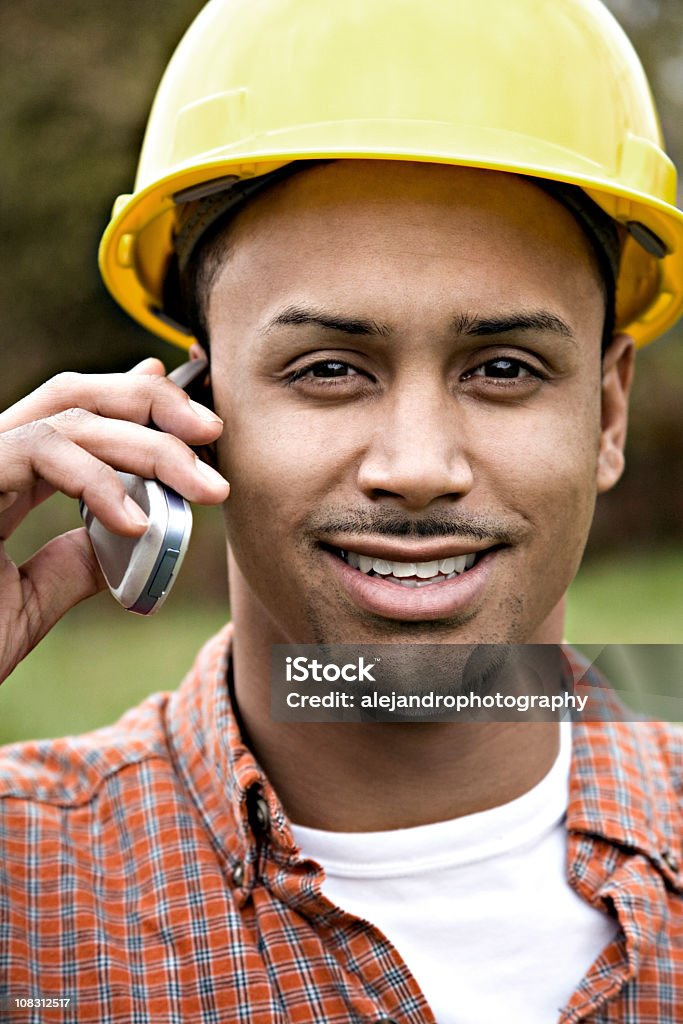 latino Trabalhador de Construção sorrindo no telefone celular - Foto de stock de 20 Anos royalty-free