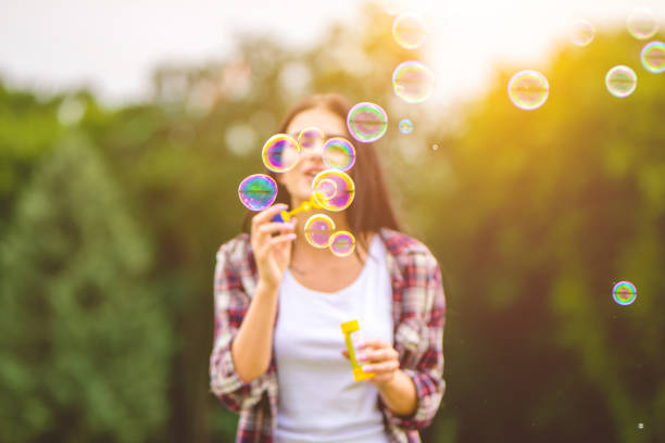 istock The young woman blowing bubbles in the park 1083125510